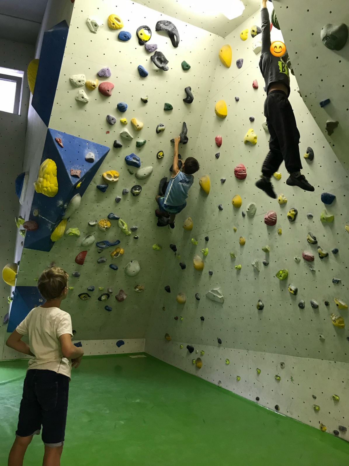 Kinder an einer Boulderwand beim Klettern