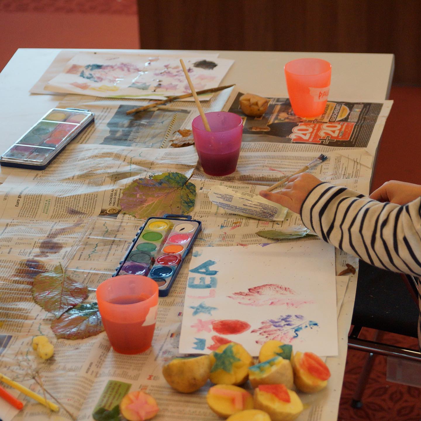 Kinder beim Malen mit Wasserfarben und Naturmaterialien